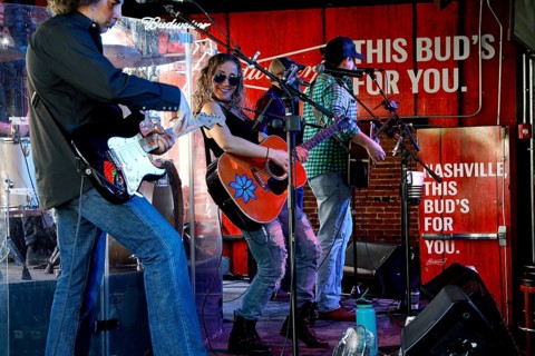 Band plays energetic music in front of a banner with the inscription 'This Bud's for You,