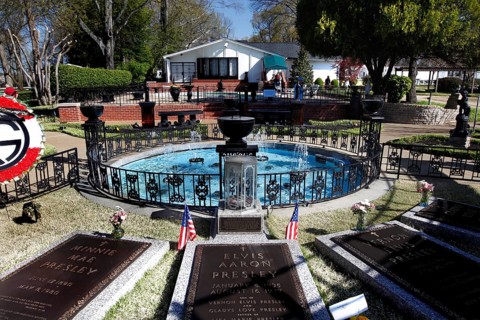 Graves with flags and a round fountain in a green setting, Memphis, Tennessee, USA