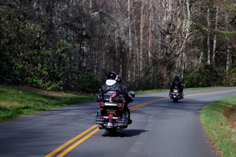 Motorcyclists ride on a winding road through wooded area, Blue Ridge Parkway, USA