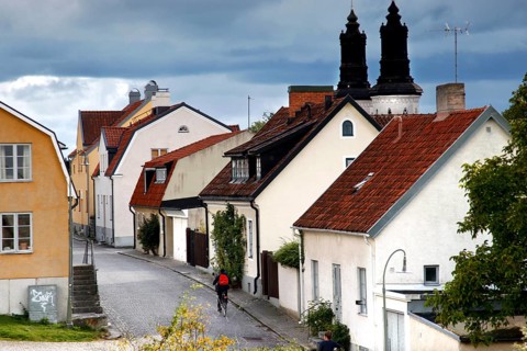 Narrow alley with traditional houses under ominous skies, Visby, Gotland, Sweden