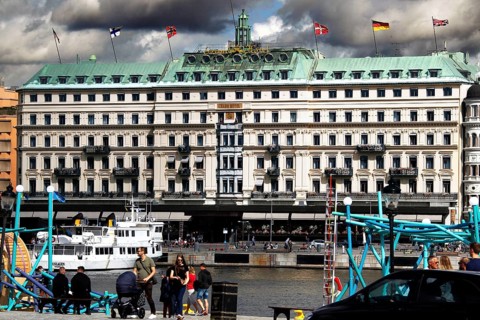 The Grand Hotel in Stockholm on Blasieholmen with a passing boat, Stockholm, Södermanland, Sweden