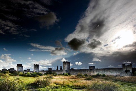 Impressive city wall of Visby with towers, under an imposing sky with dramatic clouds, Visby,