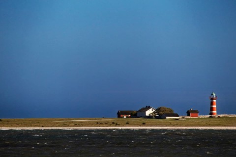 Lonely lighthouse on a quiet coastline under blue sky, Närsholmen, Gotland, Sweden