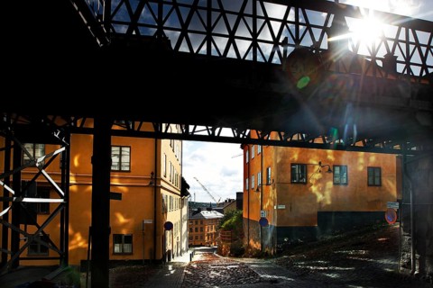 Bright buildings in Södermalm, Stockholm, in sunlight under a bridge, Stockholm, Södermanland,