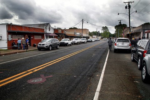 Busy main street with shops and parked cars in Mamou, Mamou, Louisiana, USA