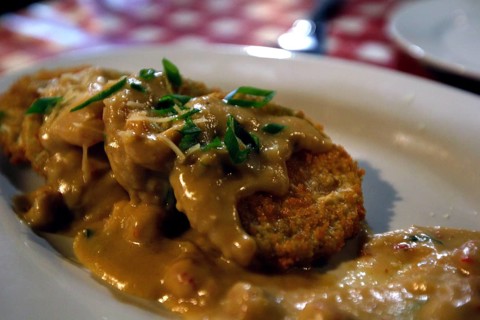 Baked green tomatoes with sauce and herbs served at Prejean's restaurant, Lafayette, Louisiana, USA