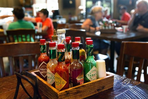 Different Tabasco bottles in the foreground of a restaurant, Avery Island, Louisiana, USA