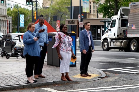 People wait at a pedestrian crossing in downtown Atlanta on Peachtree Street, Atlanta, USA