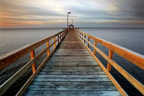 A long wooden pier stretches out into the calm sea at sunset in Biloxi, Biloxi, Mississippi, USA