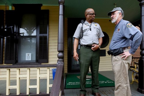Two men in uniform talk on the front porch of Martin Luther King Jr. ' s Birthplace, Atlanta,