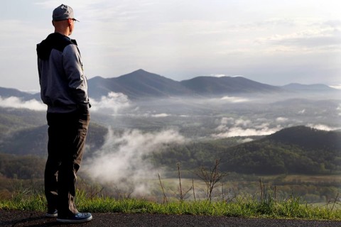 Man standing at Blue Ridge Parkway looking over misty mountain landscape, Blue Ridge Parkway,