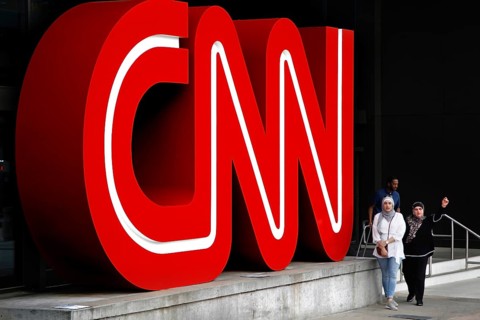 Large red CNN logo on a building, people walk past, Atlanta, Georgia, USA