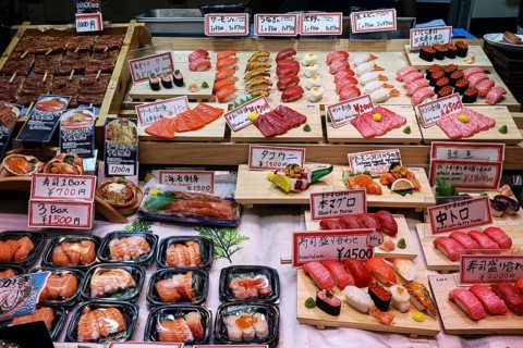 Different types of sushi presented at a market stand in Nishiki Market, Kyoto, Japan