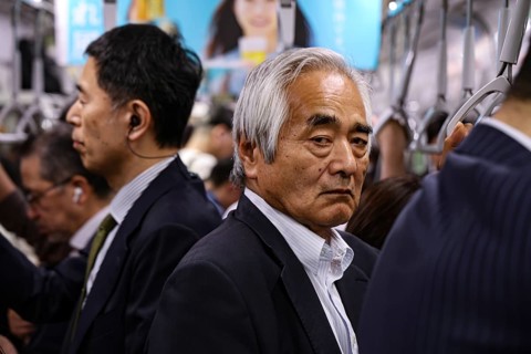 Commuters ride on a busy subway in Tokyo, Tokyo, Japan