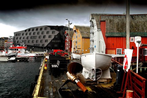Wooden houses and boats at the stormy harbor of Tromsø, Tromsø, Troms, Norway