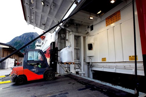 Hurtigruten ship in Øksfjord loading via a cargo hatch