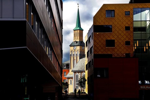View of the cathedral between modern buildings in Tromsø, Tromsø, Troms, Norway