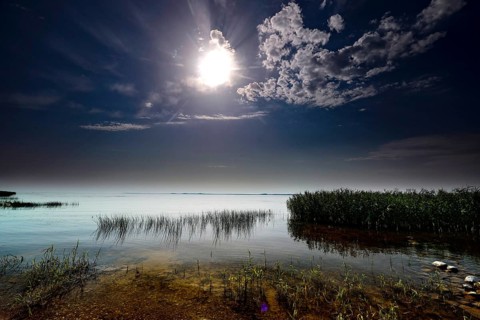 Brilliant full moon over the quiet Curonian Lagoon at night in Vente, Vente, Lithuania