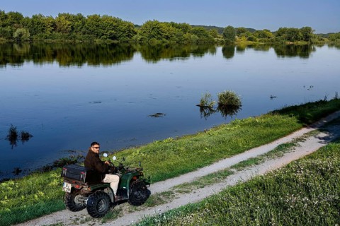 Person rides ATV on a path along the Nemunas River near Vilkija, Vilkija, Lithuania