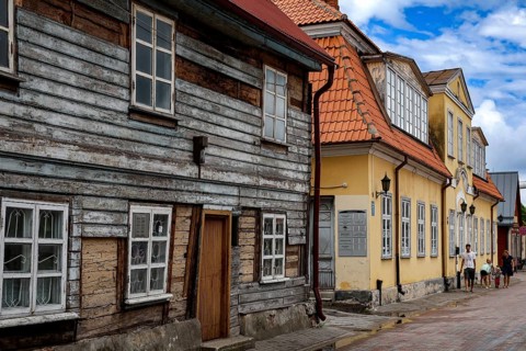 Charming old town alleyway with historic wooden houses and blue sky, Ventspils, Latvia