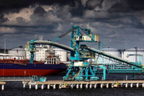 View of a harbor with cranes and a ship, dramatic clouds in the background, Ventspils, Latvia