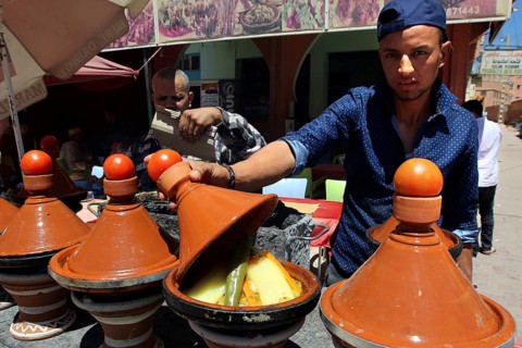 Traditional Moroccan cuisine with several brown tagine pots in a restaurant, El Kelâa m'Gouna,