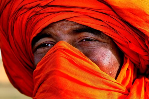 Portrait of a Bedouin wearing a bright orange turban in the Erg Chebbi Desert, Erg Chebbi, Morocco