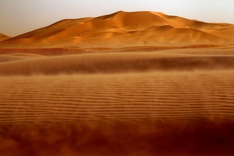 Dust envelops the sand dunes in the sprawling Erg Chebbi, Erg Chebbi, Morocco