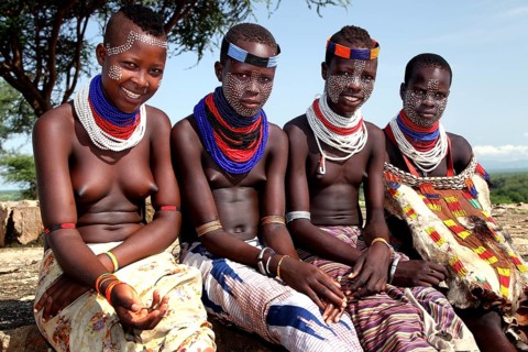 Four young woman in traditional clothing and jewelry in the village of Murle, Murle, Ethiopia
