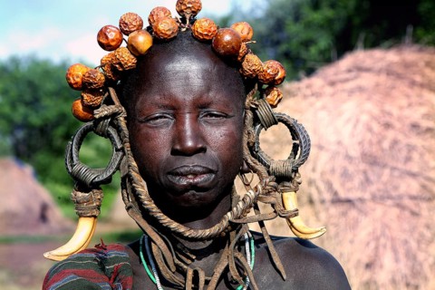 Woman wearing eye-catching headdress and traditional clothing in Mago National Park, Mago National