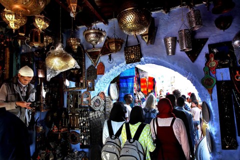 Bustling souk in the medina of Chefchaouen surrounded by blue walls and lights, Chefchaouen,