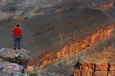 Man standing on rocks and looking at the impressive Dadès Gorge, Dadès, Morocco