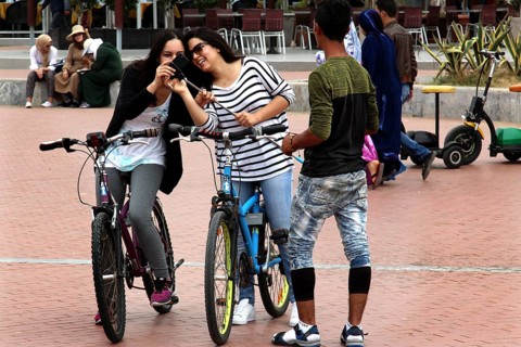 Friends enjoy a bike ride on Agadir promenade, laughing and relaxing, Agadir, Morocco