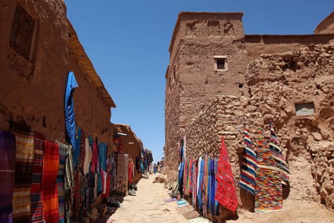 Narrow alley with colorful textile presentation in Ait Benhaddou, Ait Benhaddou, Ouarzazate,