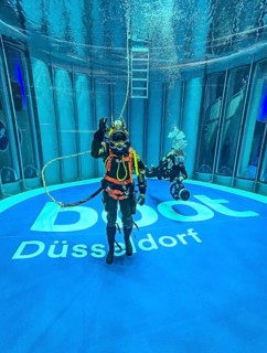 Press photo Helmet diver with modern equipment in the background Recreational diver with small