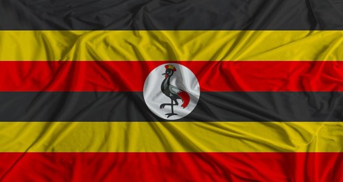 Uganda flag with fabric texture background. National flag of Uganda with cloth texture