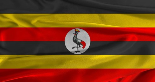 Flag of Uganda with fabric textured background. Close up of National flag of Uganda with realistic