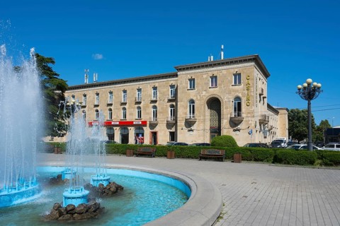 Classic building with fountain and beautiful summer atmosphere under blue skies, Stalin Park and