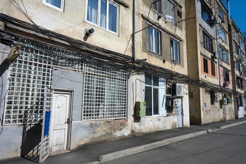 Multi-storey apartment block with lots of exposed cables and aged façade, Gori, Inner Kartli