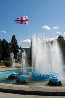 Dynamic fountain in the park with a flag in the background, Georgian flag, Stalin Park, Gori, Inner