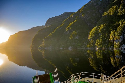 Tranquil fjord shore of Lyseford, illuminated by soft evening light with reflecting waters and dark