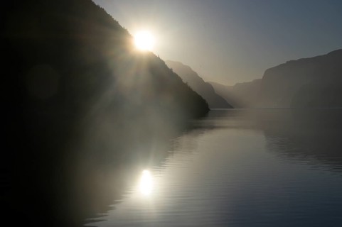 Foggy morning atmosphere over the quiet Lysefjord at sunrise between mountains