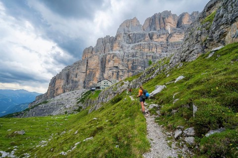 Female mountaineer on a hiking trail in front of Rifugio Maria E Alberto Ai Brentai, mountainous