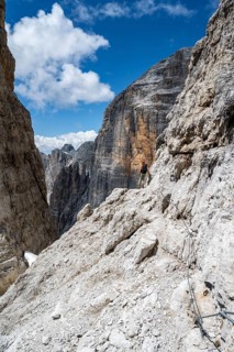 Climbers on the Via Ferrata Brentari via ferrata, spectacular mountain landscape with steep cliffs,