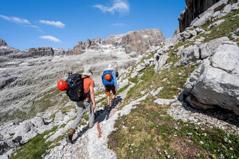 Two mountaineers on a hiking trail to Sella della Tosa, mountainous landscape in the Brenta