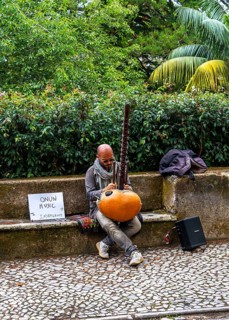 Musician sitting on the side of the N375 road in Sintra, Lisbon, Portugal