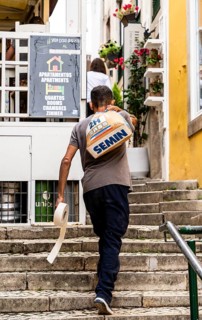 A craftsman carries a sack of cement, Sintra, Lisbon, Portugal