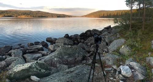 Drevsjø, Innlandet, Norway, scene of a photographer on a rocky lakeside at sunset, Gutulia National