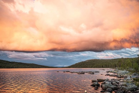 Evening cloud formation over Lake Gutulsjön illuminated by orange light, Gutulia National Park,