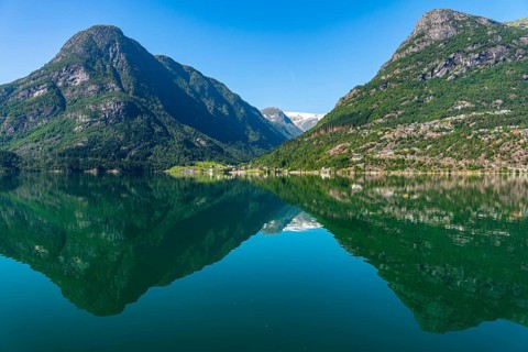 Tranquil mountain and lake landscape with clear, reflecting water surface